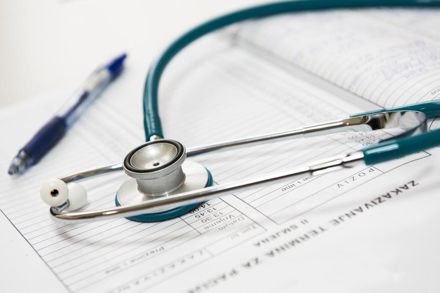 Stethoscope on top of a medical chart with a pen nearby