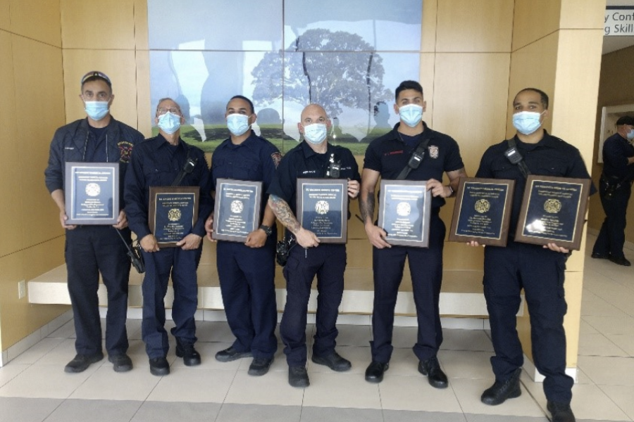 6 men stand in a line holding their EMS award plaques